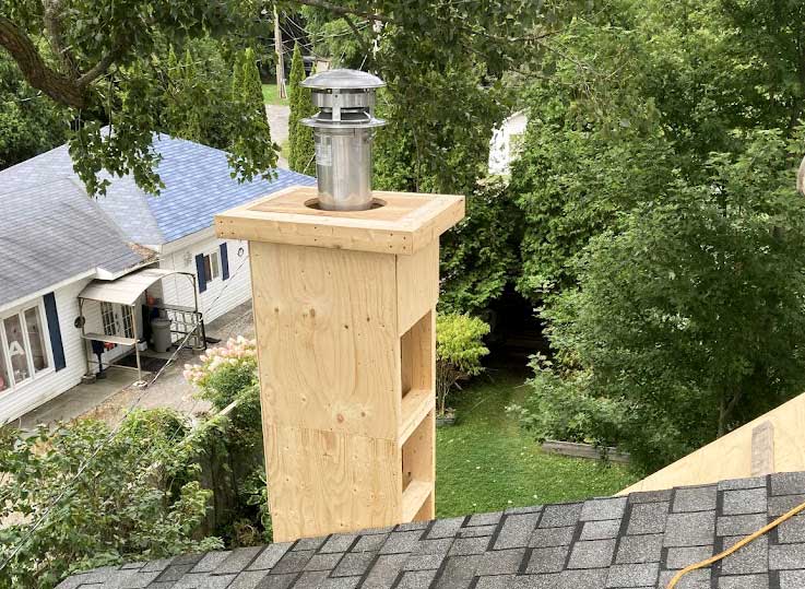 Professional chimney installation with stainless steel cap on residential home in Eastern Ontario