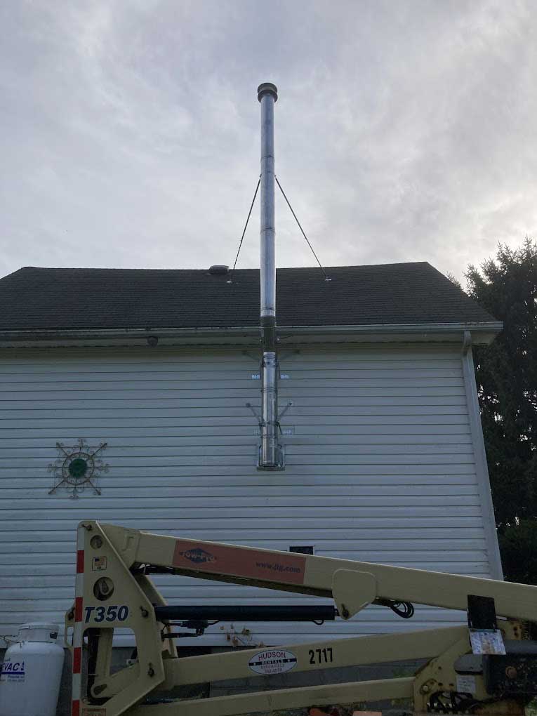 Professional chimney installation with lift equipment