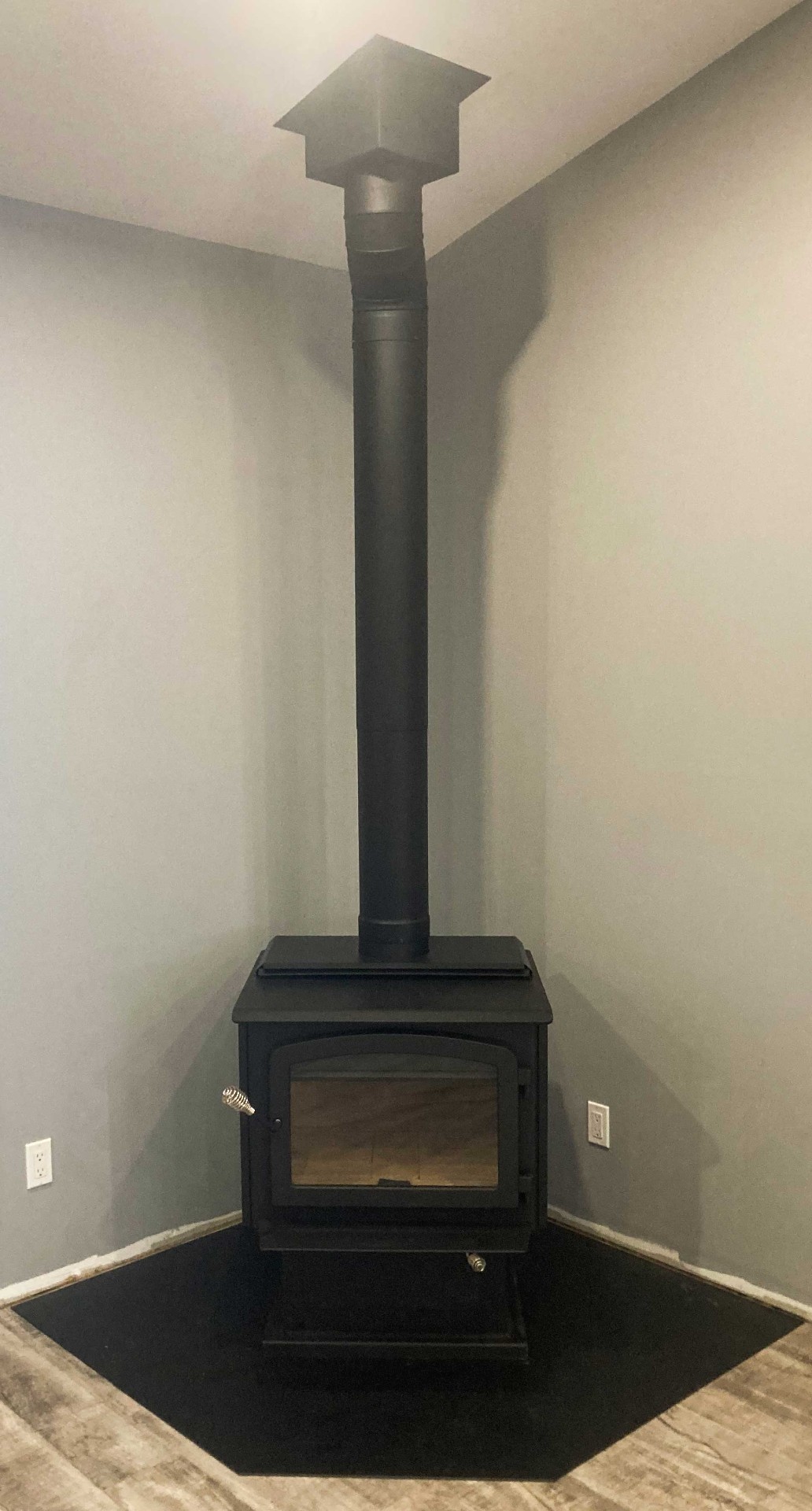 Corner wood stove installation in modern home